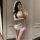 Woman in mirror wearing white sheer lace bridal lingerie set with off-shoulder sleeves and veil, romantic sleepwear style.