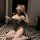 Woman in pure & playful lingerie set, sheer sleepwear with flirty bikini-style design, posing on patterned floor.