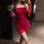 A woman poses elegantly in a vibrant red dress, holding a wine glass. the outfit features sheer details and ruching, perfect ...