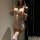 Woman modeling white sheer lingerie set with lace trim, featuring babydoll top and matching garter stockings.