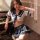 Woman in navy and white sailor-style lingerie set posing by piano; playful student-uniform sleepwear for couples.