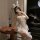 Woman wearing sheer white bunny girl lingerie set with lace details, thigh-high stockings, and playful accessories in elegant...