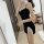 A woman poses in a black sheer sleep dress with lace details, capturing a playful yet elegant moment. the dress features deli...