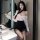 Woman in sheer white top and black skirt posing by mirror – pure & playful lingerie sleep set, sexy flirty bedroom wear.