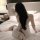 A woman sits on a bed wearing a sheer sleep dress from pure & playful lingerie, holding a plush toy. the flirty design featur...