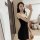 A woman poses with a teddy bear while wearing a black sheer sleep dress from the pure & playful lingerie collection, highligh...
