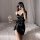 A woman poses elegantly in a black satin slip dress, featuring adjustable straps and a bow detail. she holds a wine glass, ad...