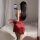 A woman poses in a red satin slip dress, capturing herself in the mirror. the sexy, adjustable-strap design features romantic...