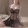 Woman wearing black sheer mesh babydoll nightgown with push-up design and pink rose details, sitting on bed.