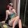 A woman poses elegantly wearing a green exotic-style bralette with floral embroidery, paired with sheer fabric accents. the d...