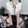 A person models a playful schoolgirl-inspired set featuring a white shirt with a black polka dot bow tie, paired with a pleat...