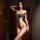 A woman poses confidently wearing a sleek black bodysuit from the pure & seductive jk uniform set, featuring an open-crotch d...