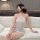 Woman wearing white lace bodysuit with blindfold, sitting on bed. pure & seductive lace bodysuit - sexy sleepwear set for wom...