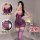 Woman modeling purple lace bodysuit with matching thigh-high stockings. romantic lingerie set features sheer fabric and bow d...