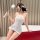 Woman in white lace bodysuit with feather wand, showcasing pure & seductive lace bodysuit - sexy sleepwear set for women.