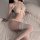 A woman poses in a delicate lace bodysuit with bows, featuring an open design and sheer fabric, perfect for intimate moments.