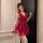 Woman wearing a deep v-neck, sheer lace chemise in rich red with ruffled layers and no-underwear design for sleep or loungewe...