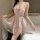 Woman wearing pink lace chemise with deep v-neck and sheer overlay, featuring bow detail and flared hem for elegant sleepwear...