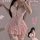 Woman wearing pink lace corset dress with ruffles and garter straps, posing seductively for bedroom romance.