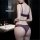 Woman wearing purple lace lingerie set in bathroom, featuring sheer bra and matching panties from pure & seductive collection...