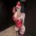 Woman wearing red lace bodysuit and thigh-high stockings, blindfolded with matching gag — pure & seductive lingerie set.