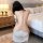 A woman wears a white lace sleep dress with a backless halter design, featuring delicate straps and cutouts, perfect for inti...