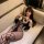 Woman lounging on a couch wearing the pure & seductive lingerie set with black fishnet stockings, featuring bunny ears and a ...