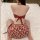Woman wearing red floral pure & seductive lingerie bodysuit, back view on white bed – tempting no-remove bedroom set for her.