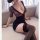 Woman wearing pure & seductive lingerie set with floral lace top and black skirt, paired with thigh-high stockings.