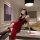 Woman wearing red lace-trimmed pure & seductive lingerie set in qipao style, posed elegantly on marble counter in luxury bedr...