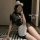 A woman poses with a smartphone, wearing a black lace qipao-style dress paired with a white apron and fluffy headband. the ou...
