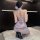 A woman kneels on a white rug wearing a sheer, floral-patterned qipao-style sleepwear set. the design features a backless top...
