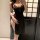 Woman in black lace-trimmed qipao-style lingerie set, modest yet alluring sleepwear with side slit and floral detailing.
