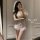 Woman in a white lace bridal lingerie set with a veil, taking a mirror selfie.