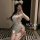 A woman poses with a smartphone, wearing a white lace qipao-inspired sleepwear set. the outfit features delicate details and ...