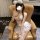 Woman in pure & seductive lingerie set with lace bodice and embroidered skirt, posing on leather chair.