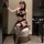 Woman in pure & seductive lingerie set – sexy qqny style jk uniform skirt, posing on ottoman with plaid top and thigh-highs.