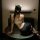 Woman in pure & seductive lingerie set, featuring open-crotch design and secretary-style top, posing on table.