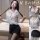 Woman wearing a sheer white blouse and black mini skirt, part of the pure & seductive lingerie set.