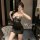 Woman posing in mirror wearing black lace lingerie set with sheer bodice and satin skirt, showcasing the pure & seductive lin...