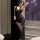 Woman wearing black sheer bodysuit with lace detailing, posing in bedroom setting. pure & seductive lingerie set - sheer mode...