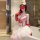 Woman in pure & seductive nurse costume set with lace bodysuit, heart detail, white tutu skirt, red gloves, and nurse hat.