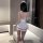 Woman in white nurse lingerie set with red trim, back view, sheer stockings, headband—pure & seductive cosplay sleepwear.