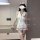 Woman modeling white nurse costume lingerie set with red cross hat, collar, belt and garters for sexy cosplay sleepwear.