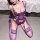 Woman wearing purple lace mesh bodysuit with underwire, sheer stockings, and garter straps in a seductive pose.