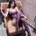 Woman in purple lace mesh bodysuit with underwire, sheer temptation outfit, seated on tan chair.
