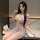 A woman poses elegantly in a sheer lace sleep dress adorned with pearls and floral patterns, exuding sensuality and grace.