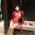 Woman wearing red sheer lace bodysuit with open-crotch mesh design, long gloves, and ribbon details.