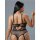 Woman wearing black sheer mesh bodysuit with open-crotch design and lace detailing, showcasing sensual lingerie from behind.