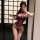 Woman in purple lace-trimmed sheer mesh bodysuit, open-crotch design, tight fit, plus size friendly, posing by mirror.